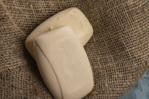 Two pieces of soap on a background of textured fabric
