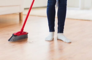 person sweeping crumbs off floor 